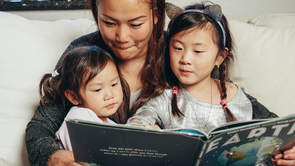 Parent and children reading a non-fiction children's book